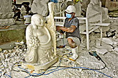 Ouvrier travaillant au marteau piqueur sur une sculpture en marbre dans l'usine de fabrication et de vente - Da Nang - Viêtnam