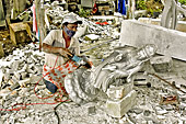Ouvrier travaillant au marteau piqueur sur une sculpture en marbre dans l'usine de fabrication et de vente - Da Nang - Viêtnam
