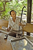Musicien jouant sur un Dàn Nhi (Violon à 2 cordes) pendant la dégustation de fruits - Ben Tre - Viêtnam